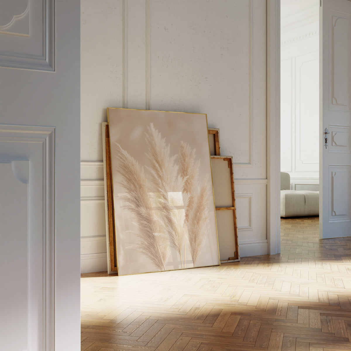 Motiv mit mehreren flauschigen Pampaswedeln in Creme und Beige vor weich verschwommenem Hintergrund, als an die Wand gelehntes Poster neben leeren Rahmen.