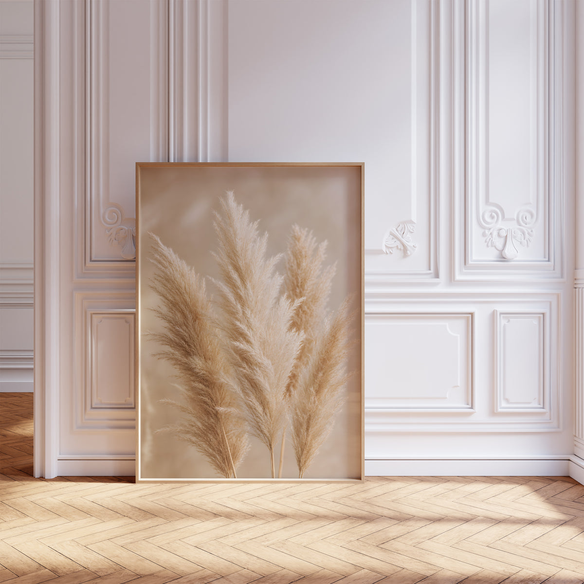 Gerahmtes Poster mit mehreren flauschigen Pampaswedeln in Creme und Beige vor weich verschwommenem Hintergrund, vor einer weißen Wand mit Zierleisten.