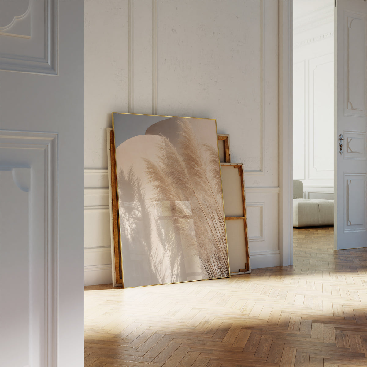 Motiv mit Pampasgräsern und ihren Schatten vor geschwungenen sandfarbenen Wänden unter blauem Himmel, als an die Wand gelehntes Poster neben leeren Rahmen.