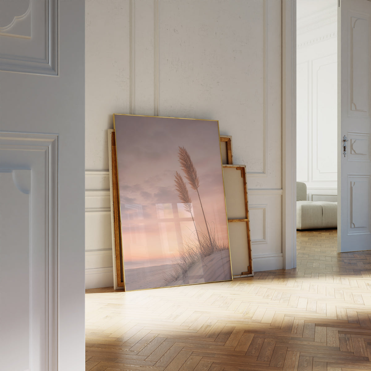 Motiv mit zwei Pampaswedeln auf einer Düne vor einem rosa-orangefarbenen Abendhimmel, als an die Wand gelehntes Poster neben leeren Rahmen.