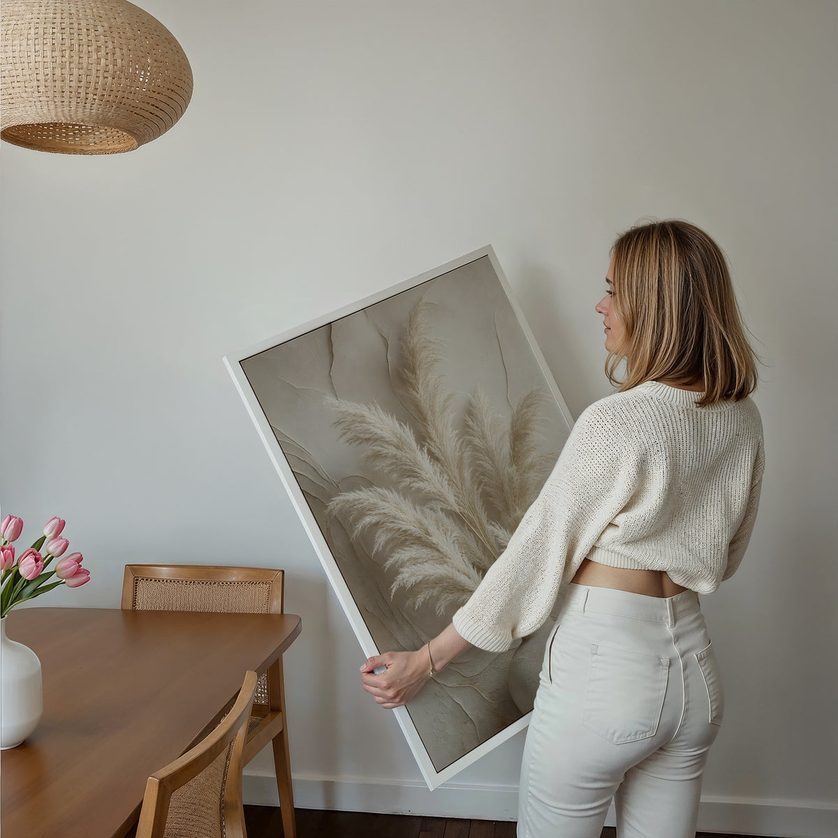 Motiv mit einem hellen Pampasbouquet in einer weißen Vase vor einer reliefartig strukturierten Wand, über einem Bett im hellen Schlafzimmer.