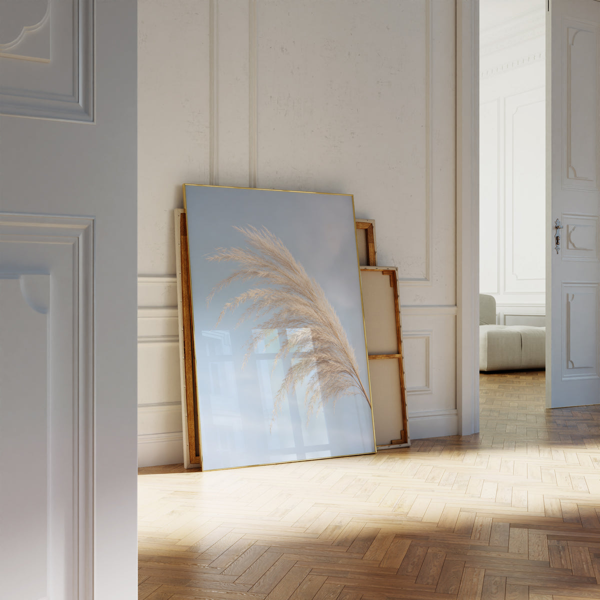 Motiv mit einem gebogenen hellen Pampaswedel vor blauem Himmel, als an die Wand gelehntes Poster neben leeren Rahmen.