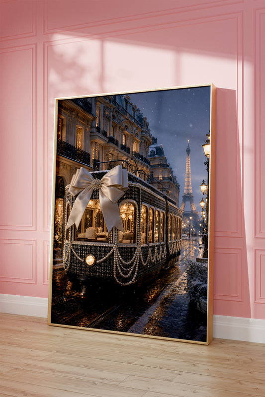 Motiv mit dunkler Pariser Straßenbahn mit großer Satinschleife und Perlenketten im Abendlicht, als gerahmtes Poster vor einer rosafarbenen Wand.