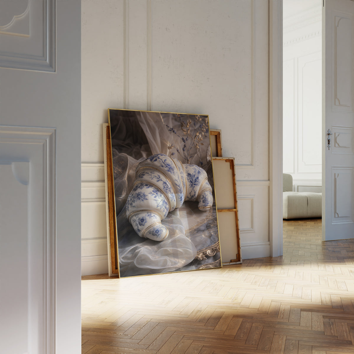 Motiv mit einem weiß-blauen Croissant in Porzellanoptik mit goldenen Verzierungen, als an die Wand gelehntes Poster neben leeren Rahmen.