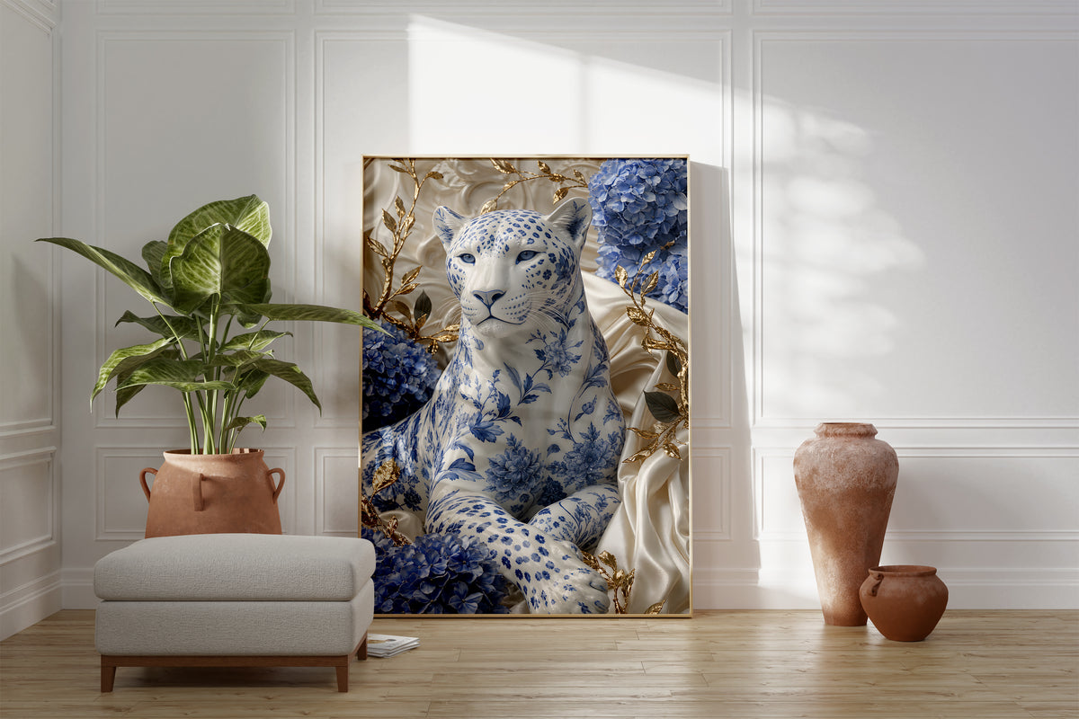 Motiv mit weißem Panther mit blauem Porzellanmuster zwischen Hortensien und goldenen Zweigen, als gerahmtes Poster neben Sessel und Zimmerpflanze.