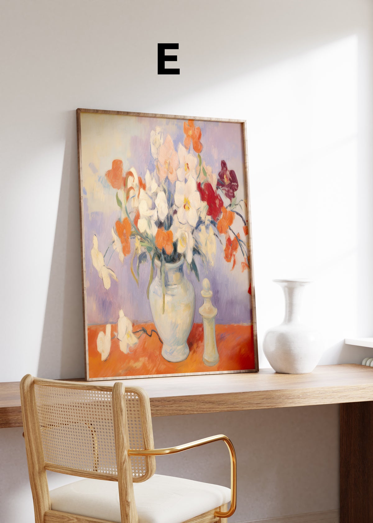 Postermotiv E: Weiße und orange Blüten in einem hellen Krug auf einem roten Tisch. Im Holzrahmen auf einem Schreibtisch.