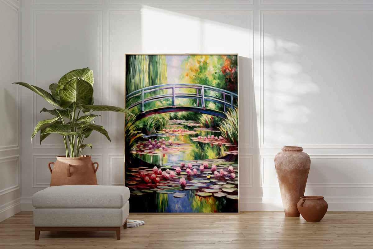 Großes gerahmtes Poster an einer hellen Wohnzimmerwand neben Sessel, Pflanze und Vase. Motiv: Geschwungene Brücke über einem Teich mit rosa Seerosen und grünen Weidenzweigen.