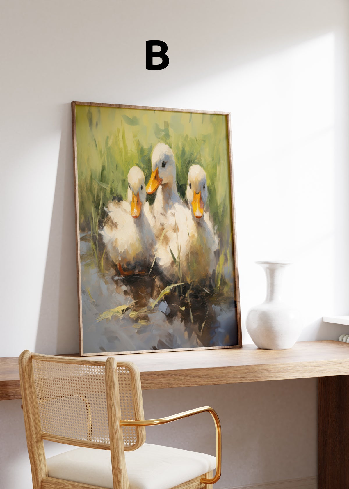 Postermotiv B: Drei helle Entenküken mit orangefarbenen Schnäbeln am Wasser. Im Holzrahmen auf einem Schreibtisch.