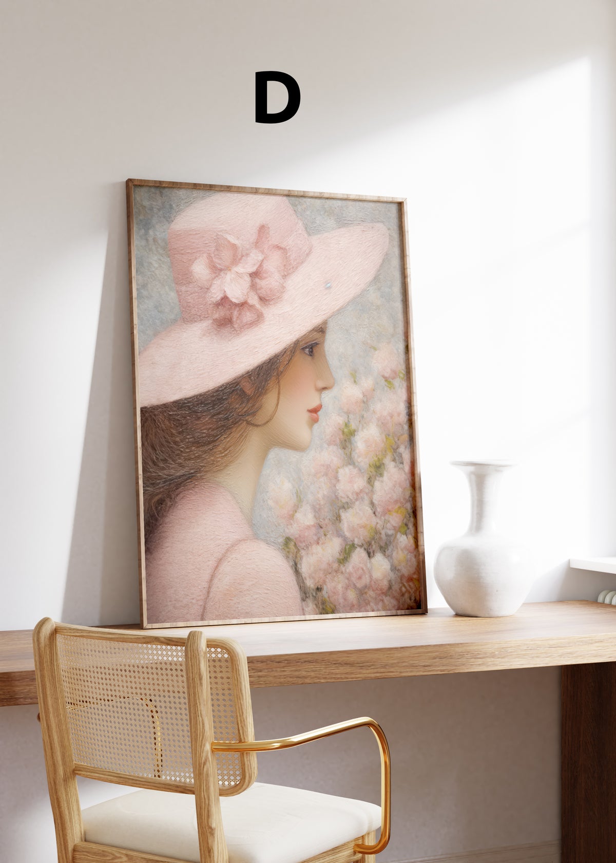 Postermotiv D: Profilporträt einer Frau mit breitem rosa Hut neben zarten Blüten. Im Holzrahmen auf einem Schreibtisch.
