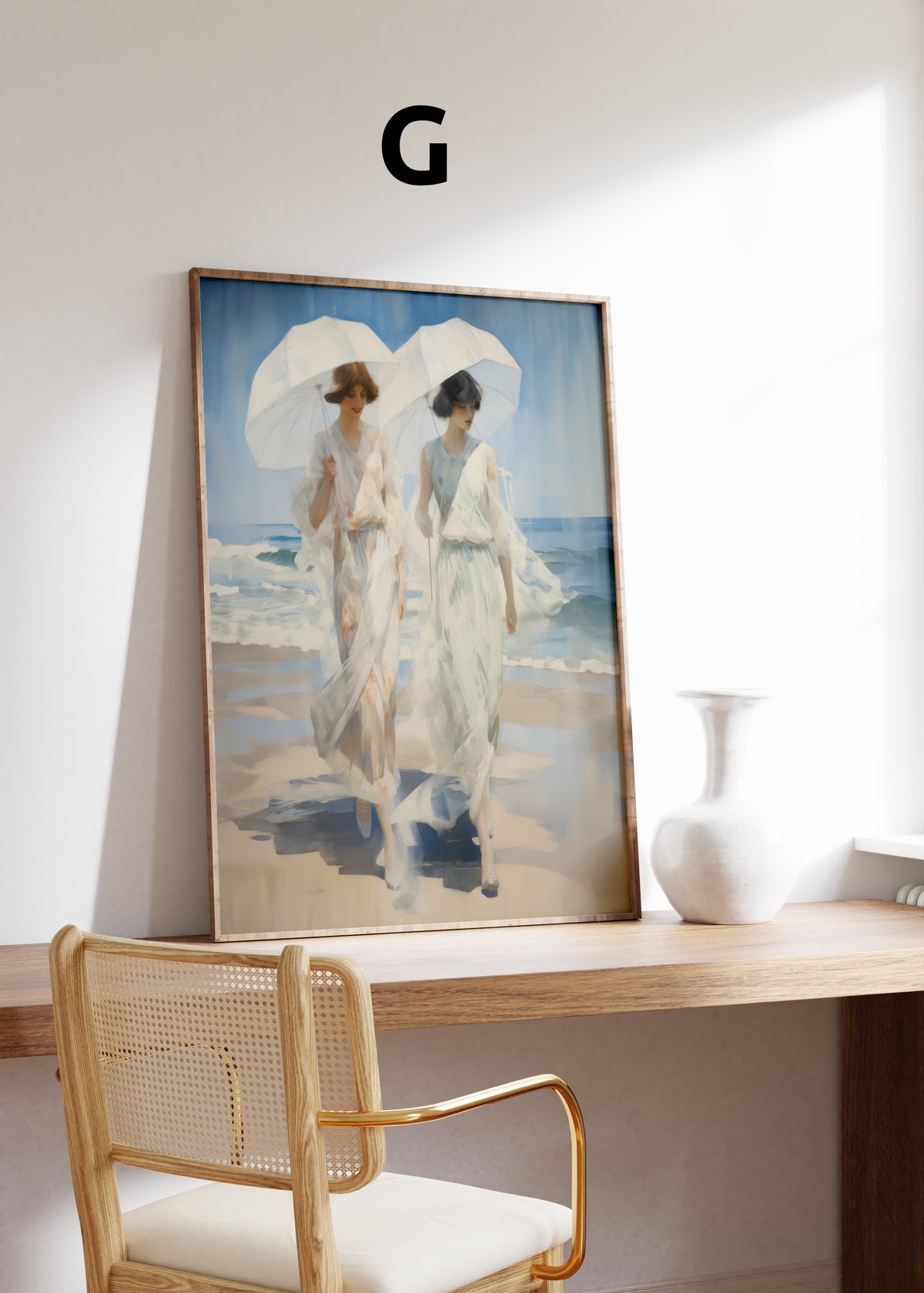 Postermotiv G: Zwei Frauen in weißen Kleidern mit Sonnenschirmen am Strand. Im Holzrahmen auf einem Schreibtisch.