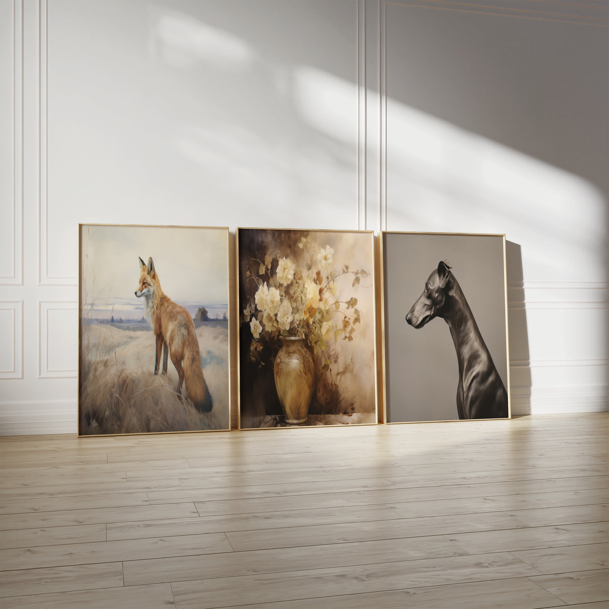 Drei gerahmte Poster an einer hellen Wand mit Zierleisten. Motive: Ein Fuchs auf grasbewachsenen Dünen vor einer weiten Landschaft; Weiße Blüten in einer bauchigen Vase in warmen Brauntönen; Schwarzer Windhund im Profil vor einem taupefarbenen Hintergrund.