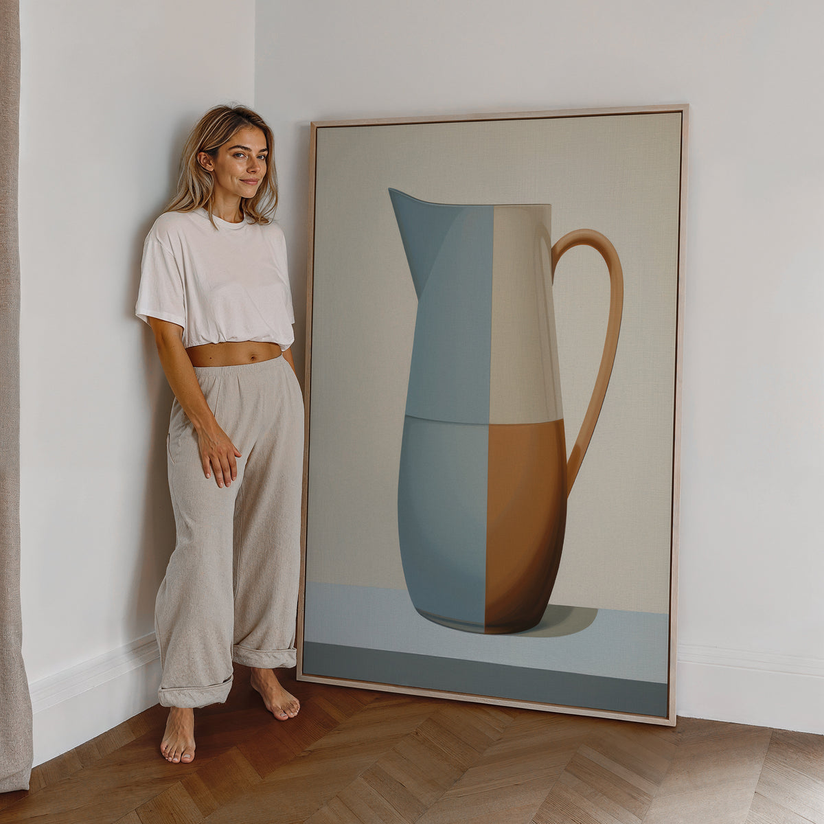 Eine Frau steht neben einem großen gerahmten Poster. Motiv: Geometrisch gestalteter Krug in Blau, Creme und Braun.