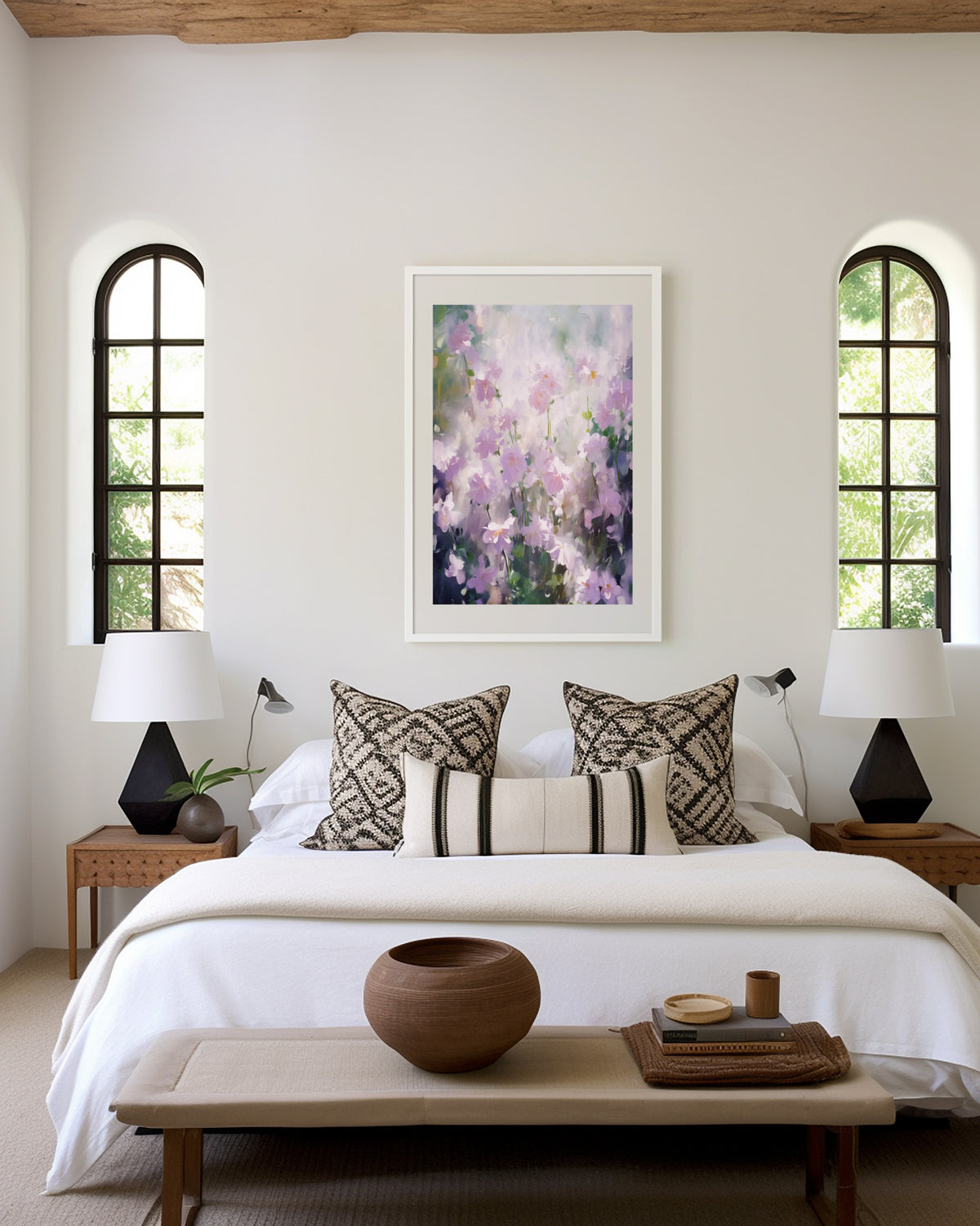 Gerahmtes Poster über einem Bett im hellen Schlafzimmer. Motiv: Zarte lila und weiße Blüten in einer weichen Pastellmalerei.
