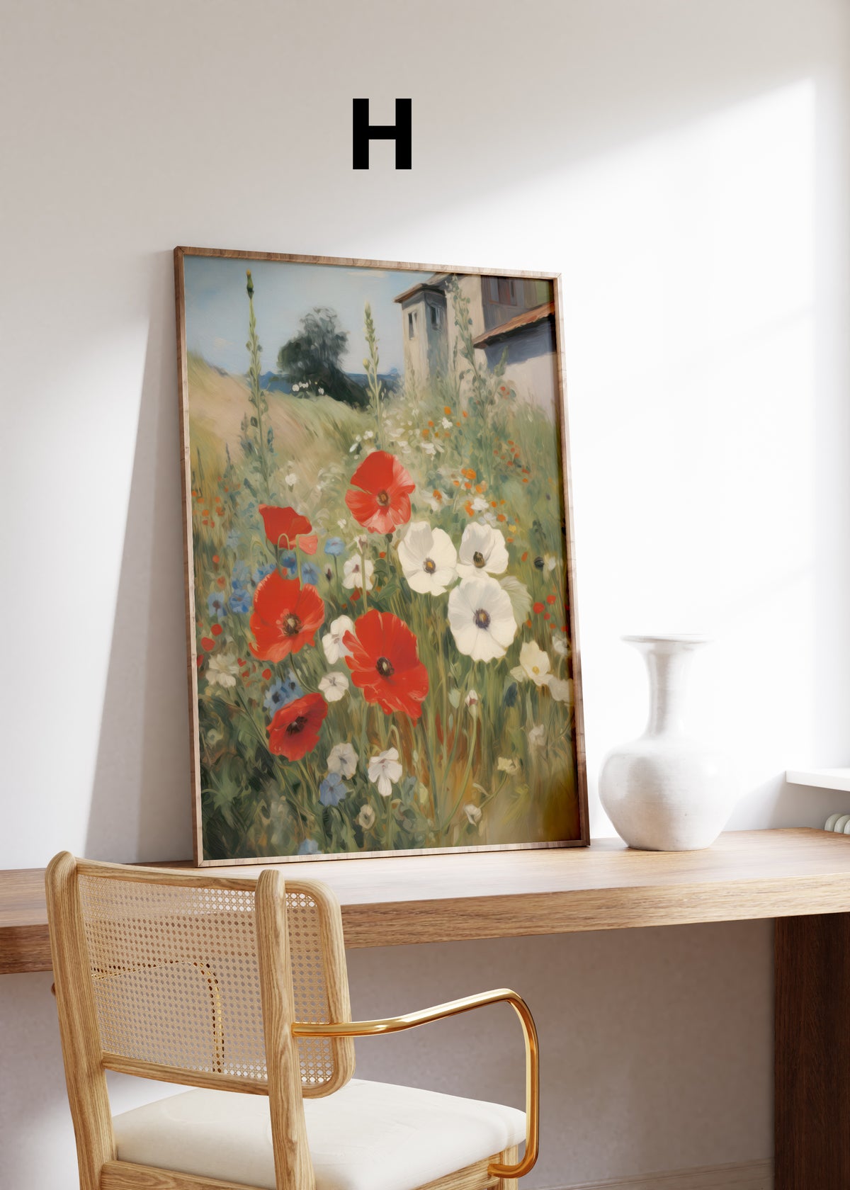 Postermotiv H: Rote und weiße Mohnblumen auf einer Wiese neben einem Landhaus. Im Holzrahmen auf einem Schreibtisch.