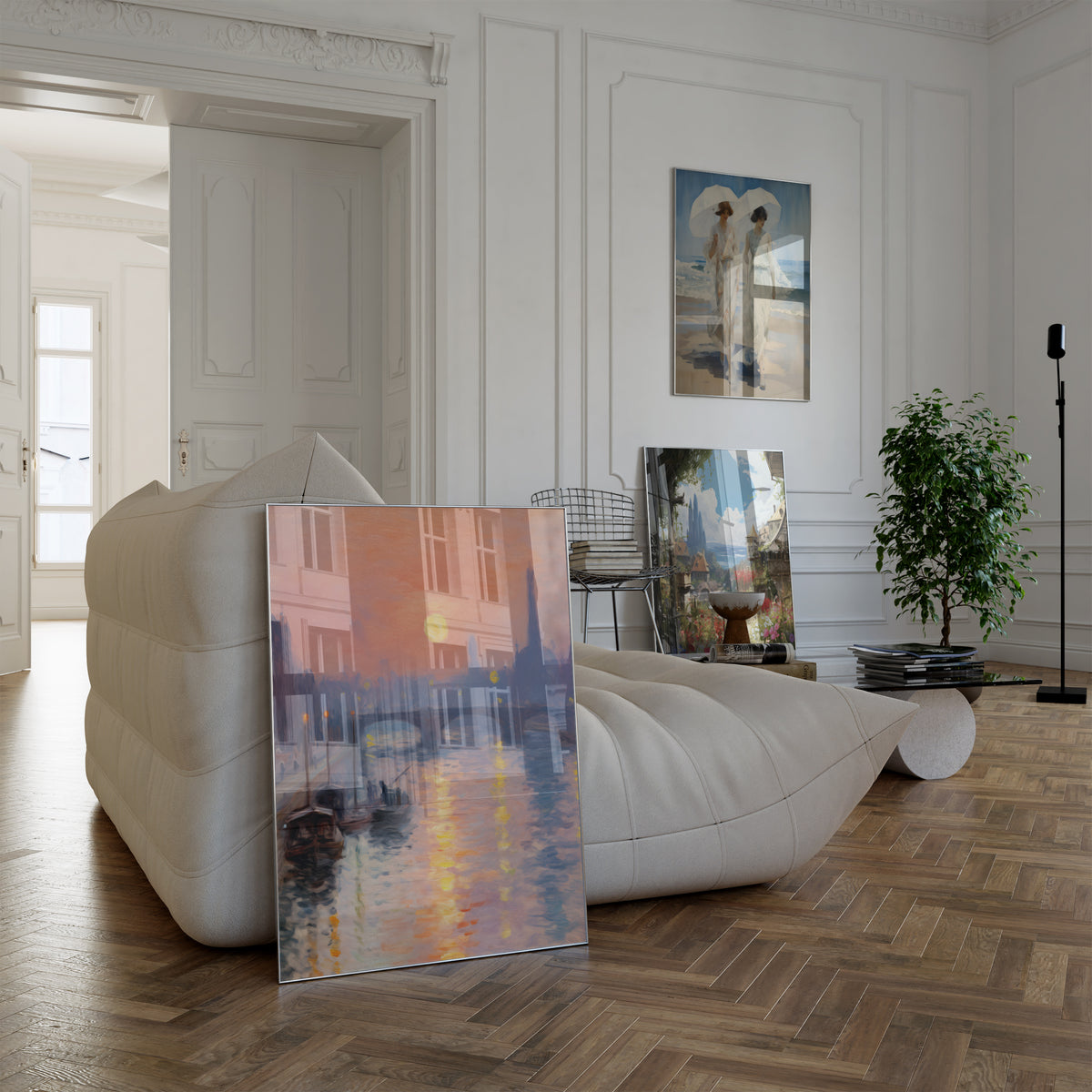 Poster in einem hellen Wohnzimmer mit weißem Sofa. Motive: Pariser Flusslandschaft mit Brücke und Eiffelturm im rosa Abendlicht; Zwei Frauen in weißen Kleidern mit Sonnenschirmen am Strand; Sonnige Gasse mit bunten Blumen und Blick über eine Küstenstadt.