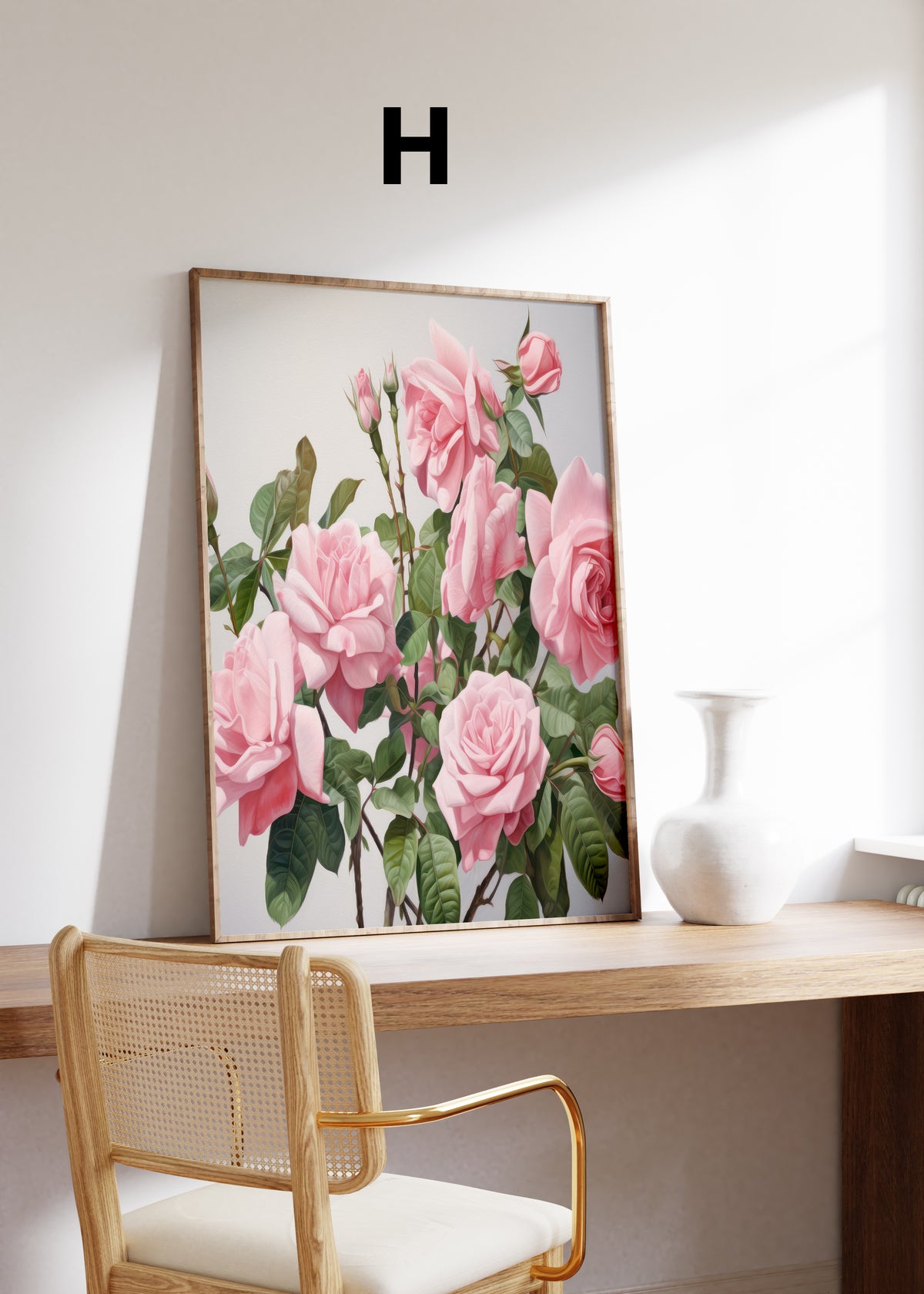 Postermotiv H: Rosa Rosen an grünen Zweigen vor hellem Hintergrund. Im Holzrahmen auf einem Schreibtisch.