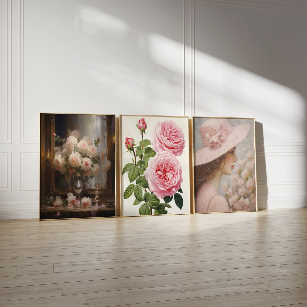 Drei gerahmte Poster an einer hellen Wand mit Zierleisten. Motive: Rosa und weiße Rosen in einer silberfarbenen Vase vor einem dunklen Spiegel; Botanische Darstellung rosa Rosen mit Knospen und grünen Blättern; Profilporträt einer Frau mit breitem rosa Hut neben zarten Blüten.
