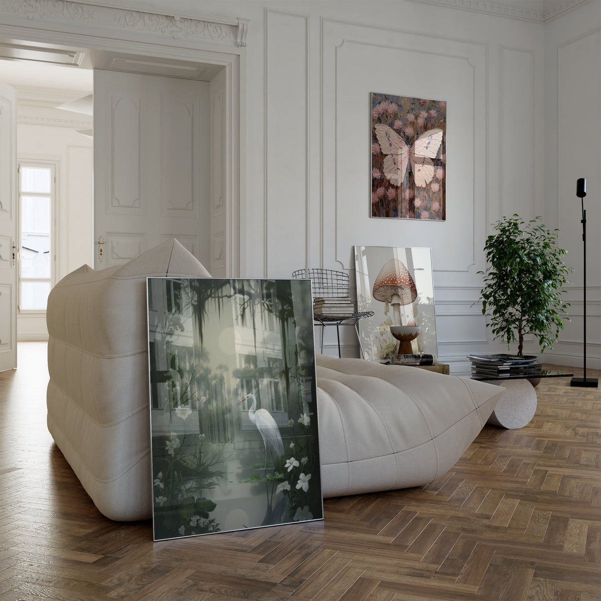 Poster in einem hellen Wohnzimmer mit weißem Sofa. Motive: Weißer Reiher an einem stillen Teich unter einem hellen Mond und dunklen Baumzweigen; Großer rosa Schmetterling zwischen strukturierten rosa Blüten; Botanische Darstellung eines großen und eines kleinen Fliegenpilzes vor hellem Hintergrund.