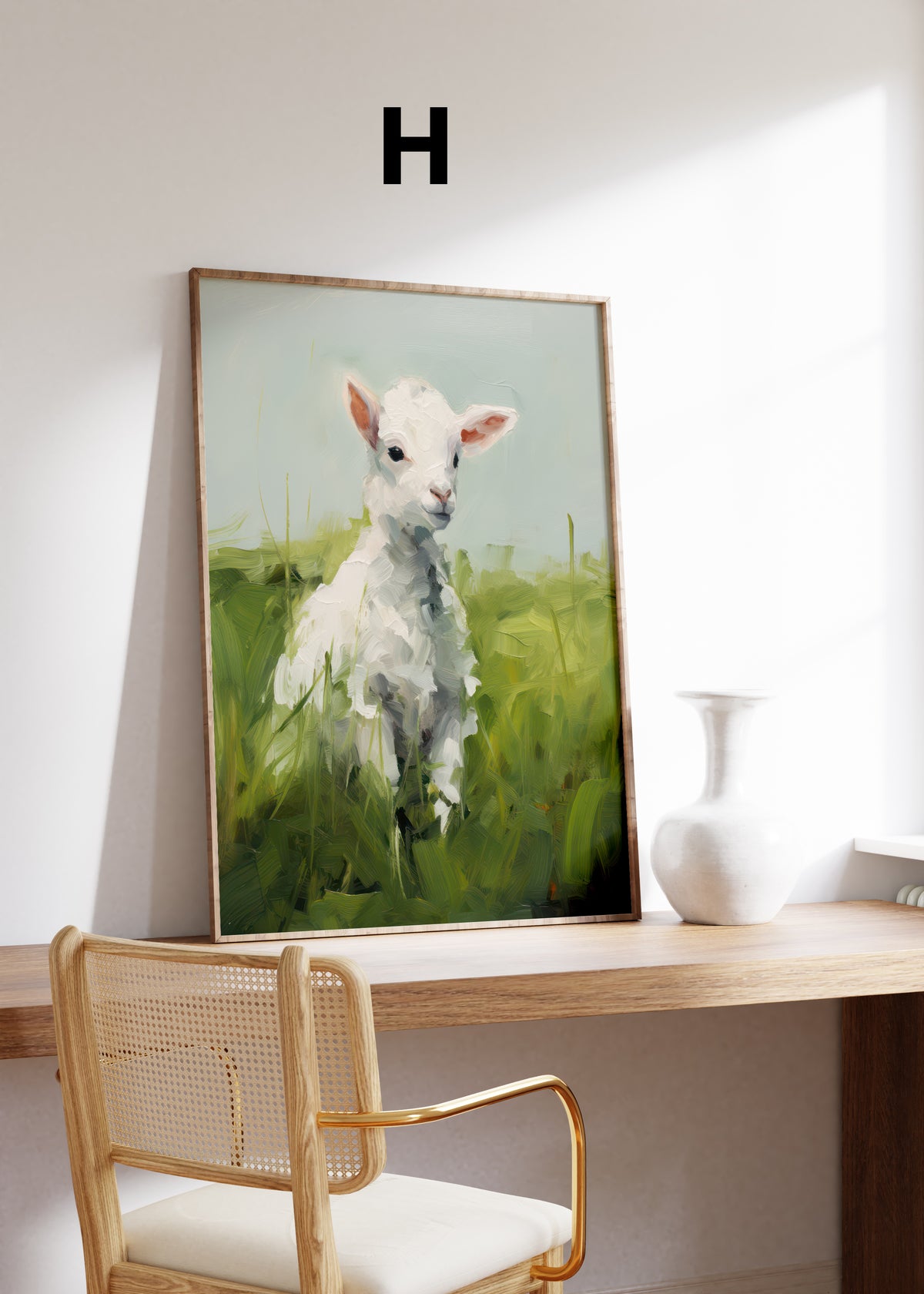 Postermotiv H: Weißes Lamm auf einer grünen Wiese. Im Holzrahmen auf einem Schreibtisch.