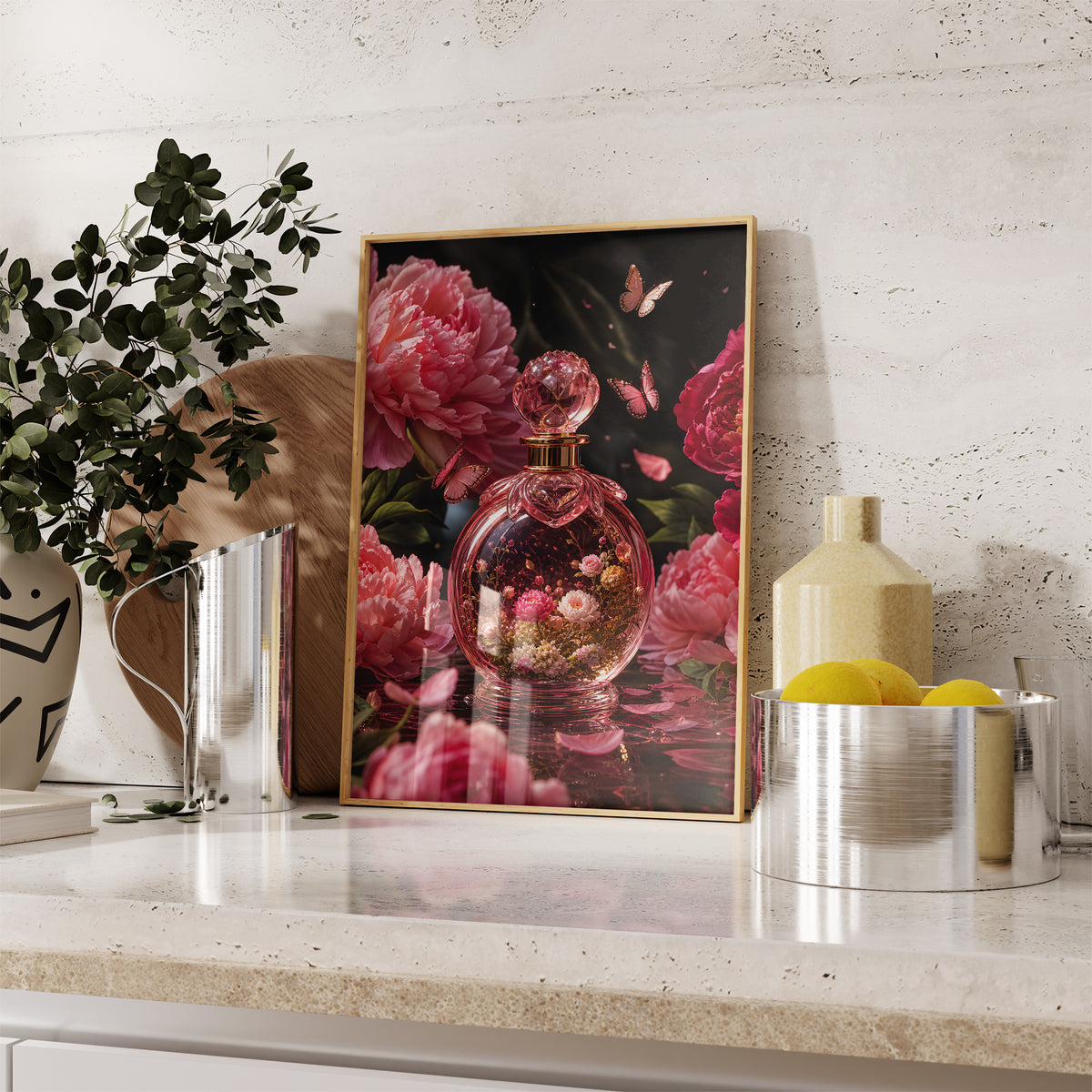 Gerahmtes Poster mit einem rosafarbenen Parfumflakon mit Blüten zwischen Pfingstrosen und Schmetterlingen, auf einer Küchenarbeitsplatte neben Pflanzen und Zitronen.