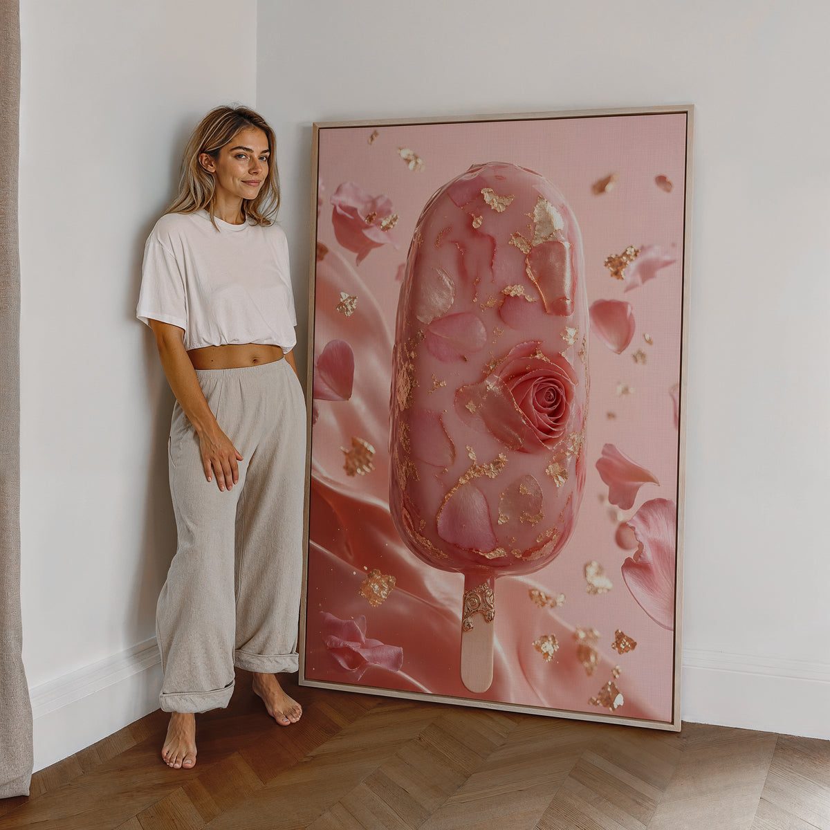 Motiv mit einem rosafarbenen Eis am Stiel mit Rosenblüten und Blattgold, als großes gerahmtes Wandbild neben einer Frau.