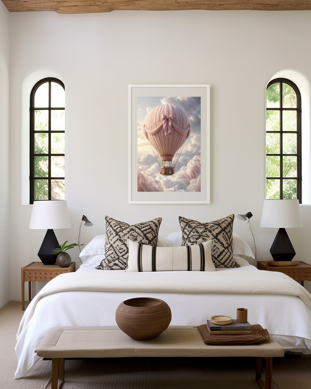 Motiv mit einem rosafarbenen Heißluftballon in Strickoptik mit Satinschleife über Wolken, als gerahmtes Poster in den Händen einer Frau.