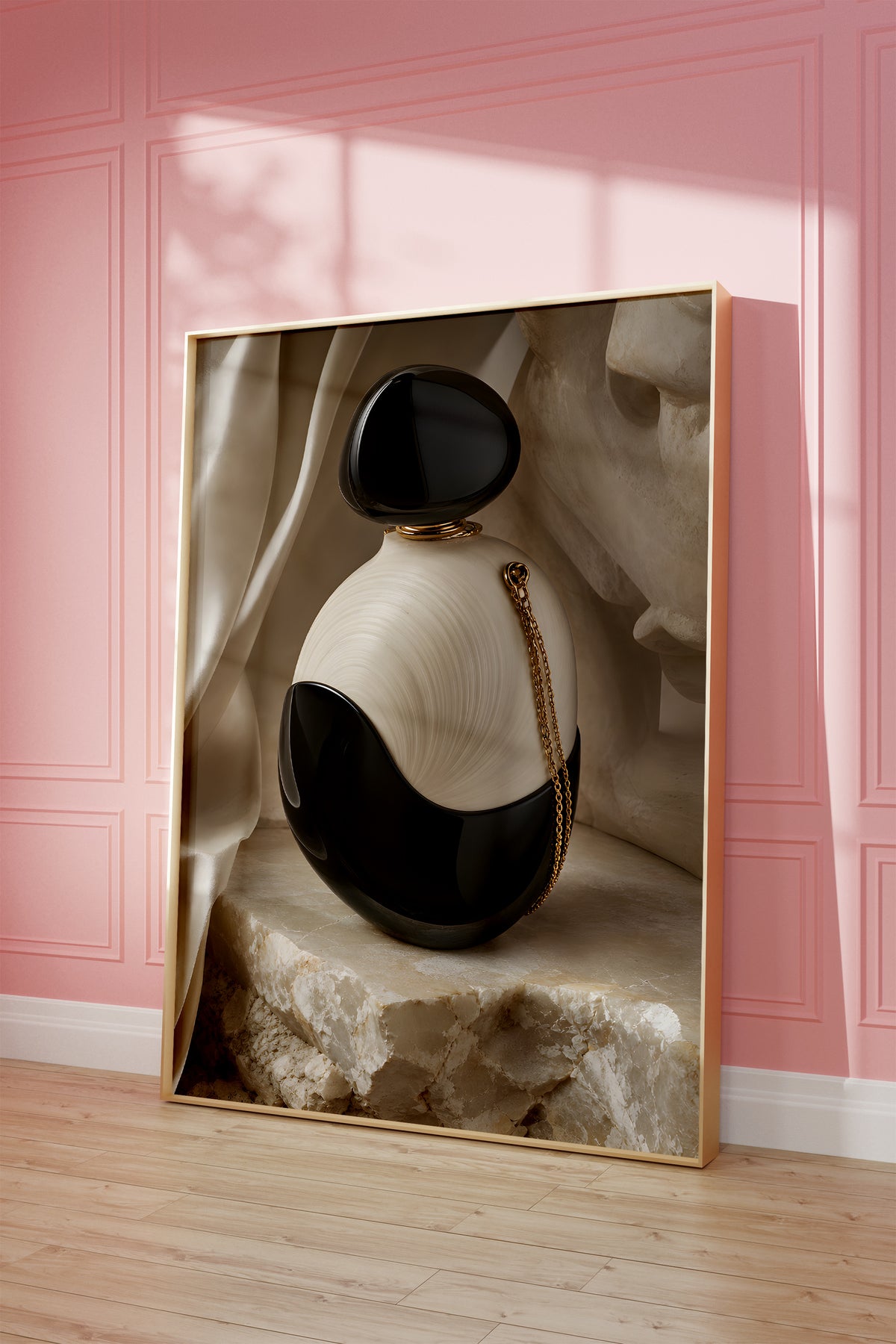 Motiv mit einem schwarz-weißen Parfumflakon mit einer goldenen Kette auf hellem Stein, als gerahmtes Poster vor einer rosafarbenen Wand.