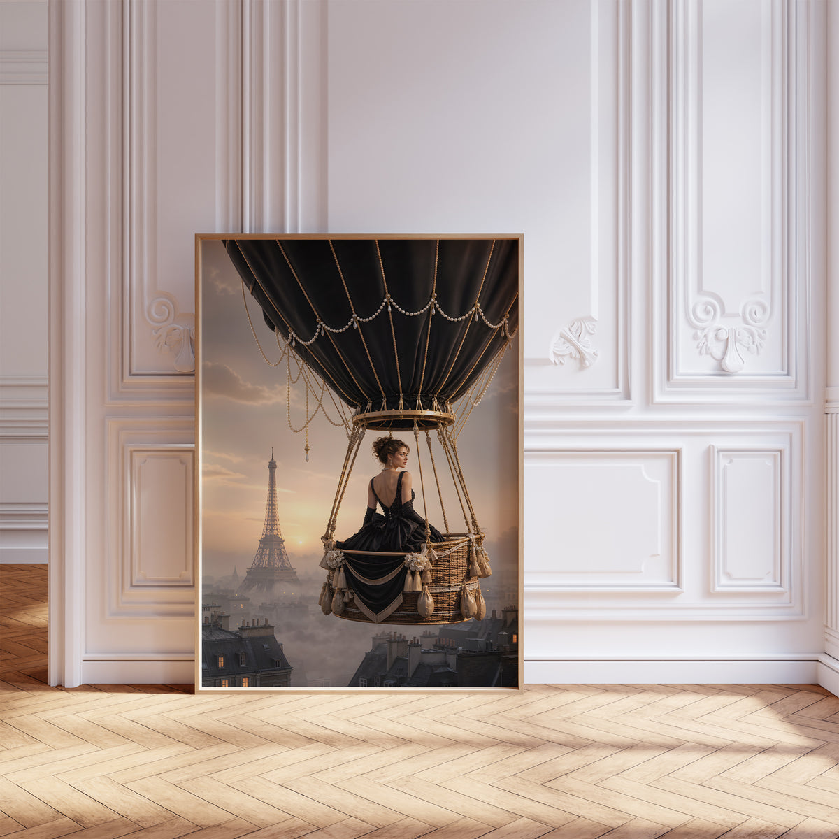 Gerahmtes Poster mit einer Frau im schwarzen Kleid im Korb eines schwarzen Heißluftballons über Paris, vor einer weißen Wand mit Zierleisten.