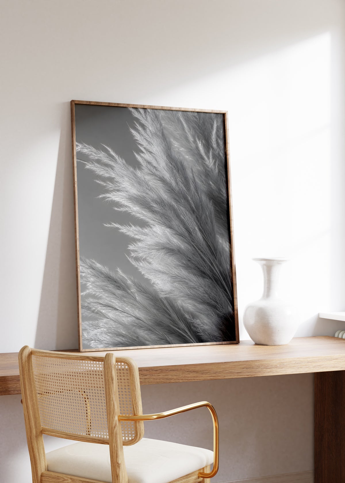 Gerahmtes Poster mit silbergrauen Pampasfasern in einer dichten monochromen Nahaufnahme, auf einem Holztisch neben einer weißen Vase.