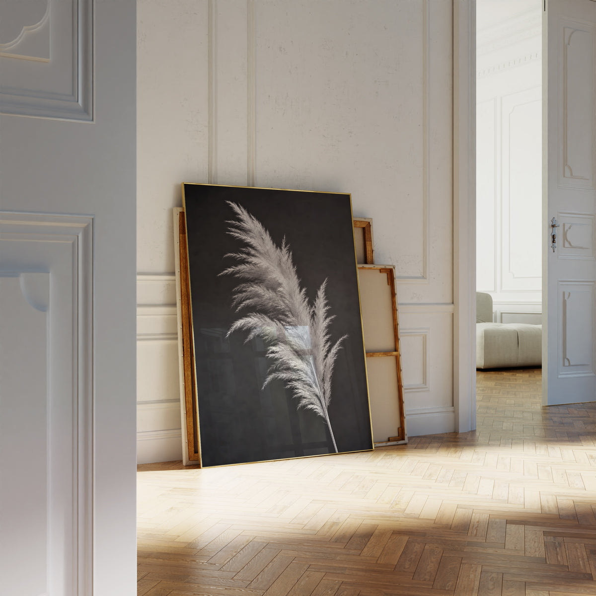 Motiv mit einem silbrig hellen Pampaswedel vor schwarzem Hintergrund, als an die Wand gelehntes Poster neben leeren Rahmen.