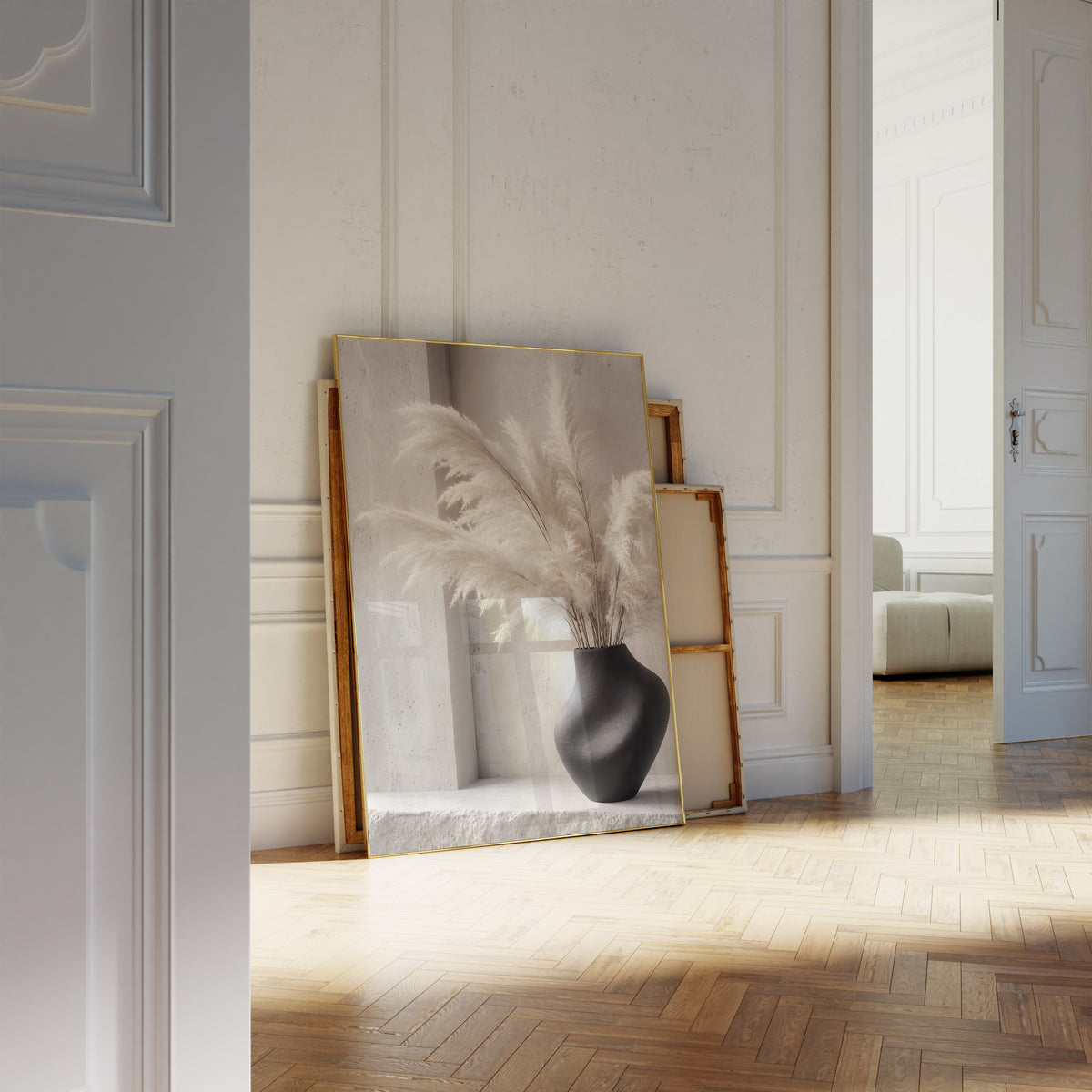 Motiv mit weißen Pampaswedeln in einer schwarzen geschwungenen Vase, als an die Wand gelehntes Poster neben leeren Rahmen.